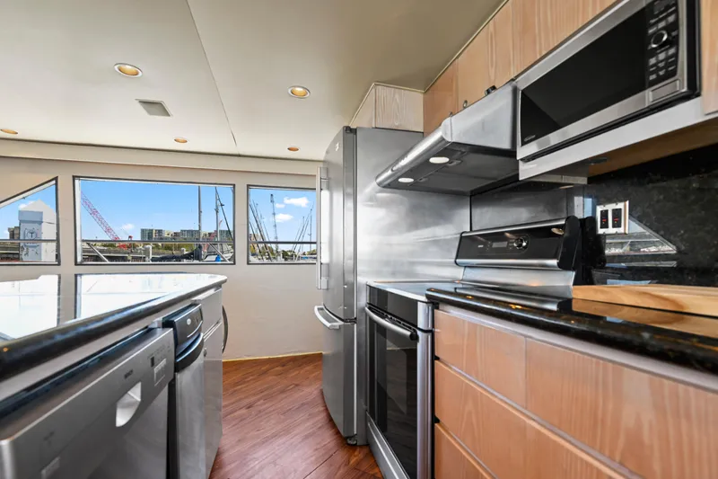 Miss Emily Yacht Photos Pics Modern kitchen in 1990 Broward Motor Yacht Extraordinaire with stainless steel appliances and wood flooring.