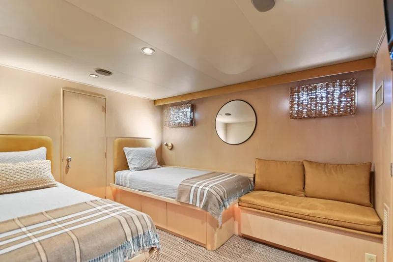 Miss Emily Yacht Photos Pics Luxurious 1990 Broward Motor Yacht bedroom with twin beds and cozy seating area.
