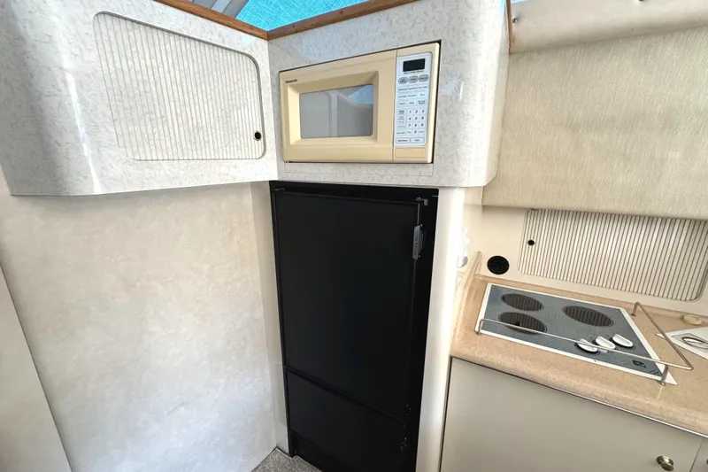Lady Slipper Yacht Photos Pics 1996 Sea Ray 400 Sedan Bridge kitchen with microwave, fridge, and stove.