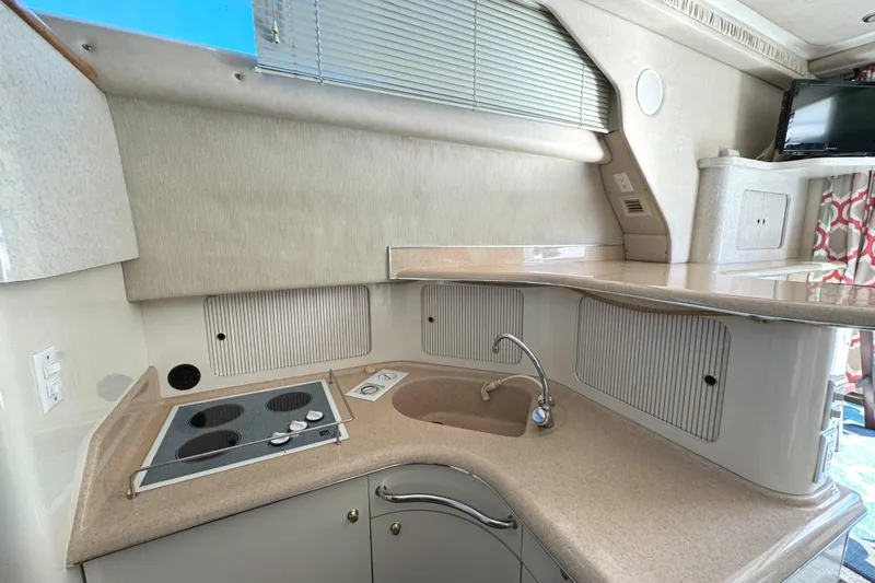 Lady Slipper Yacht Photos Pics 1996 Sea Ray 400 Sedan Bridge kitchen with stove, sink, and storage cabinets.