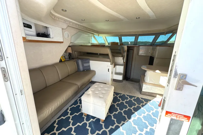 Lady Slipper Yacht Photos Pics Interior of 1996 Sea Ray 400 Sedan Bridge with beige seating and blue patterned rug.