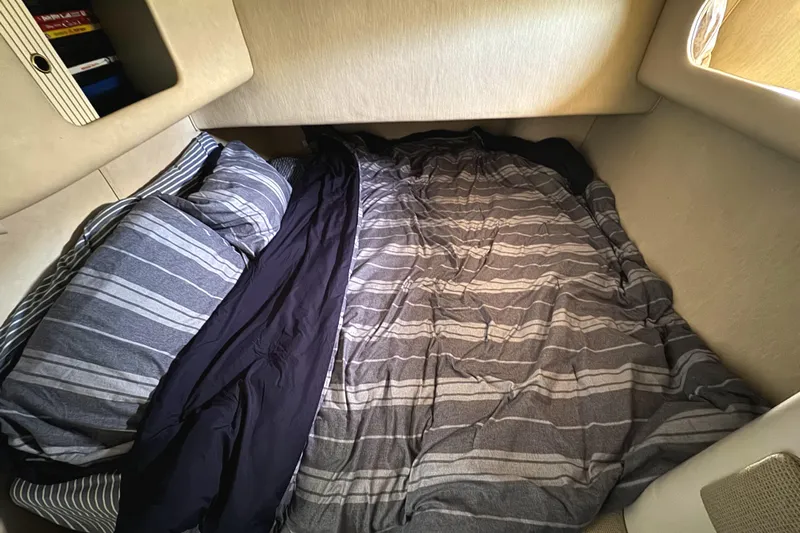 Lady Slipper Yacht Photos Pics Cozy cabin bed in 1996 Sea Ray 400 Sedan Bridge with striped bedding.