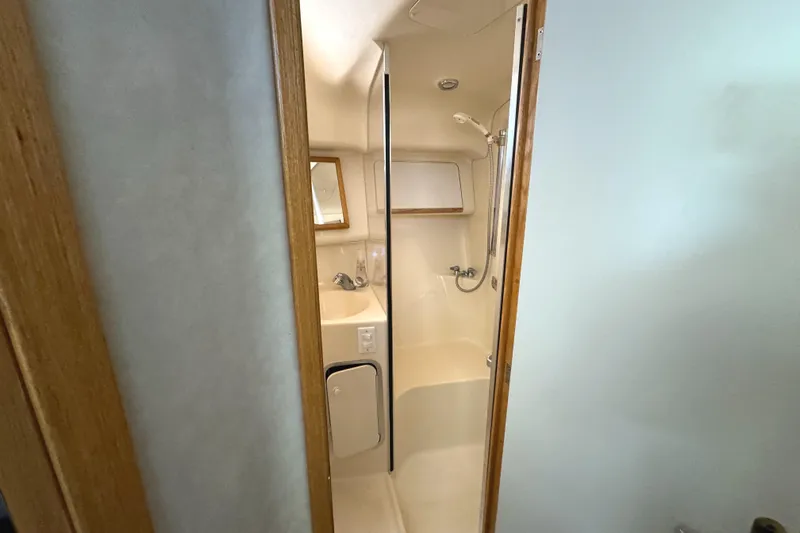 Lady Slipper Yacht Photos Pics Bathroom interior of 1996 Sea Ray 400 Sedan Bridge yacht, featuring shower and sink.