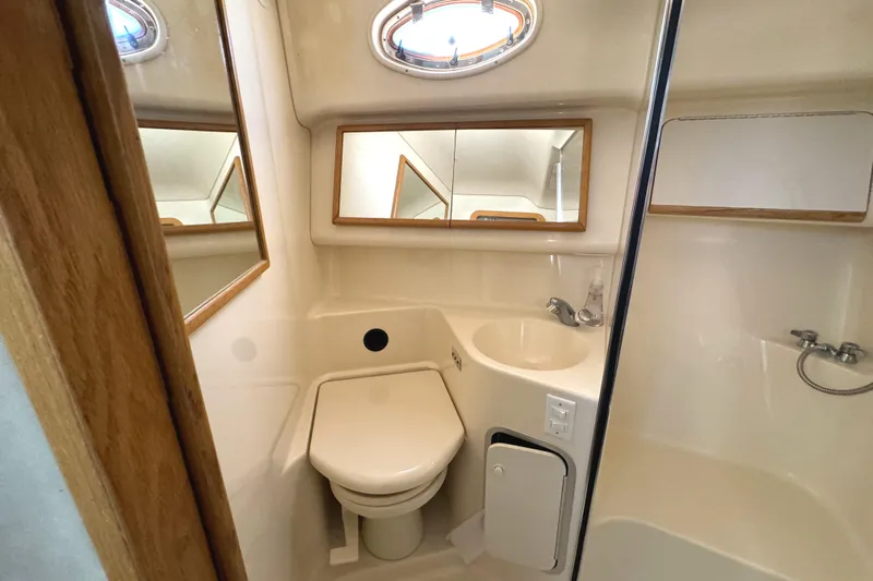 Lady Slipper Yacht Photos Pics Bathroom interior of 1996 Sea Ray 400 Sedan Bridge yacht, featuring toilet and sink.