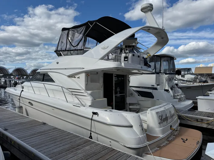 Lady Slipper Yacht Photos Pics 1996 Sea Ray 400 Sedan Bridge docked at marina under cloudy sky.
