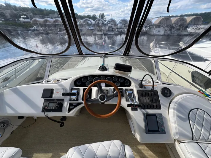 Lady Slipper Yacht Photos Pics 1996 Sea Ray 400 Sedan Bridge helm with wood steering wheel and modern controls.
