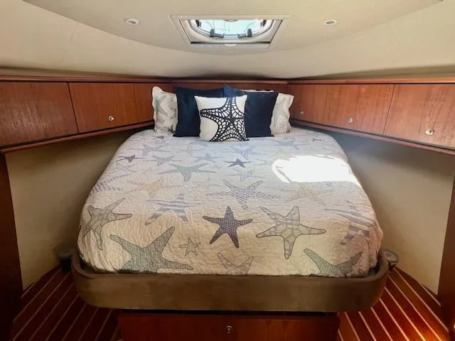  Yacht Photos Pics 2007 Tiara Yachts 3900 Sovran cabin with starfish-themed bedding and wooden cabinetry.