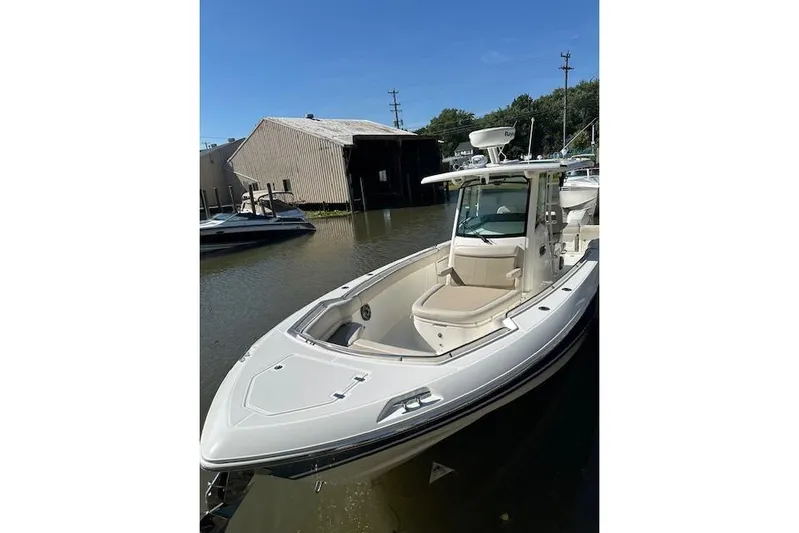 Yacht Photos Pics 2016 Boston Whaler 330 Outrage boat docked near a boathouse.