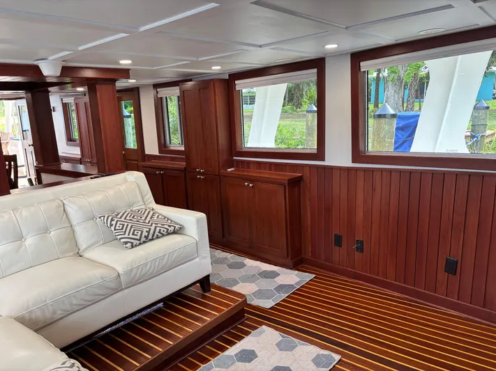 Restless T Yacht Photos Pics Luxurious 1971 Sermons Expedition yacht interior with wood paneling and white leather seating.