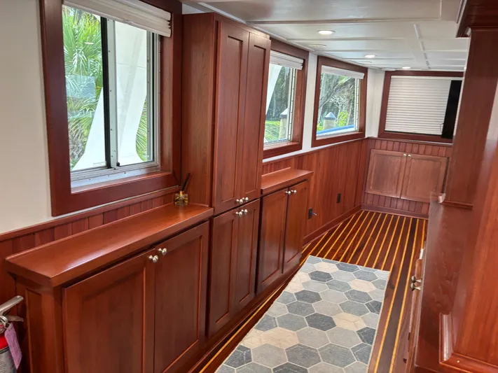 Restless T Yacht Photos Pics 1971 Sermons Expedition interior with wooden cabinets, striped flooring, and large windows.