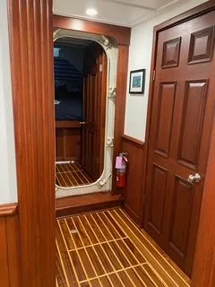 Restless T Yacht Photos Pics Wood-paneled hallway on 1971 Sermons Expedition boat with fire extinguisher and framed picture.