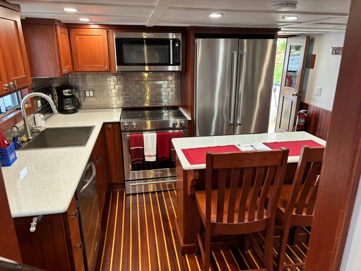 Restless T Yacht Photos Pics Modern kitchen in a 1971 Sermons Expedition boat with wood cabinetry and stainless steel appliances.