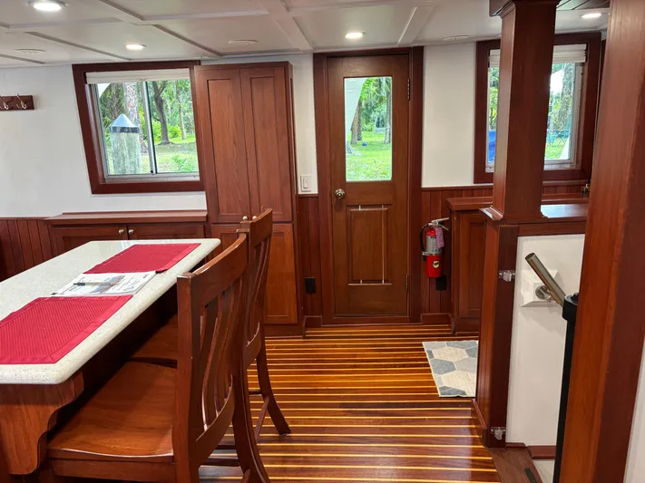 Restless T Yacht Photos Pics 1971 Sermons Expedition interior with wooden decor, dining area, and striped flooring.