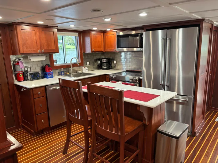 Restless T Yacht Photos Pics Modern kitchen in 1971 Sermons Expedition boat with wooden cabinets and stainless steel appliances.