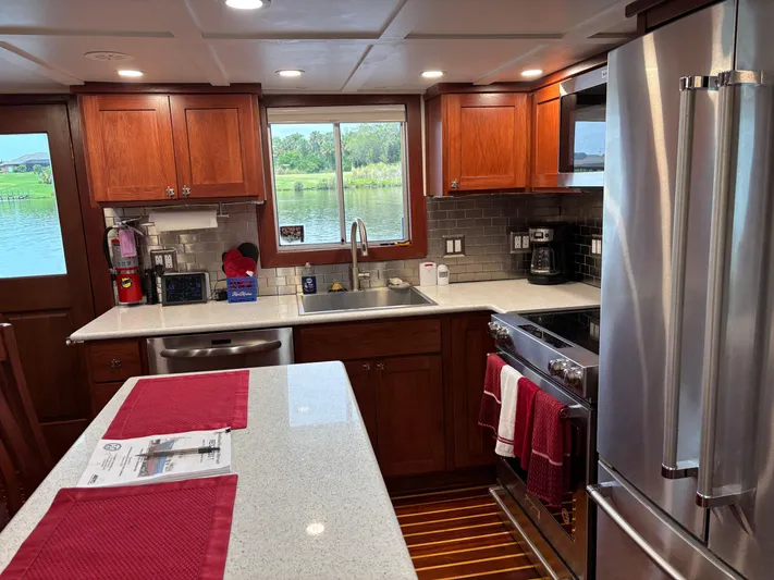 Restless T Yacht Photos Pics 1971 Sermons Expedition kitchen with wooden cabinets, stainless steel appliances, and a scenic window view.