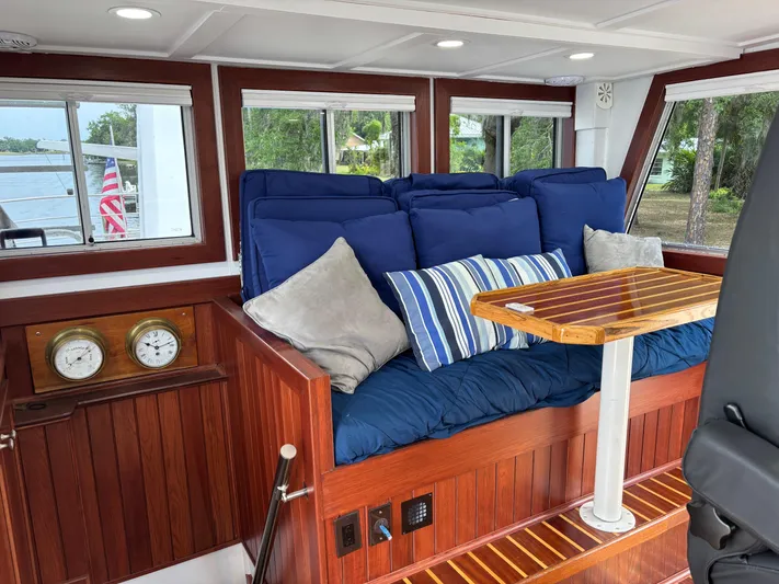 Restless T Yacht Photos Pics Cozy 1971 Sermons Expedition boat interior with blue cushions, striped pillows, and wooden accents.