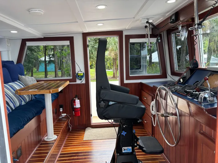 Restless T Yacht Photos Pics 1971 Sermons Expedition boat interior with wooden paneling, steering wheel, and seating area.
