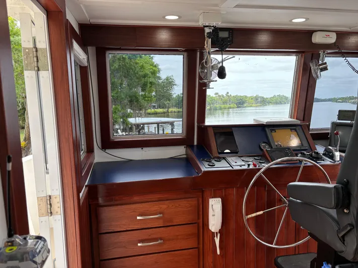 Restless T Yacht Photos Pics 1971 Sermons Expedition boat interior with wooden helm, steering wheel, and navigation equipment.