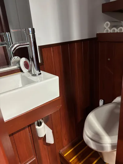 Restless T Yacht Photos Pics 1971 Sermons Expedition bathroom with wooden paneling, modern sink, and toilet.