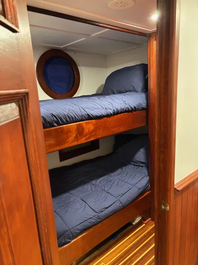 Restless T Yacht Photos Pics 1971 Sermons Expedition boat cabin with wooden bunk beds and blue bedding.