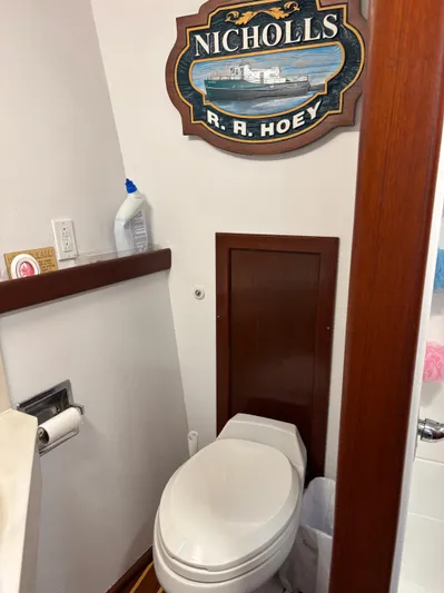Restless T Yacht Photos Pics Small bathroom with toilet, wooden accents, and nautical-themed "Nicholls R.A. Hoey" sign.