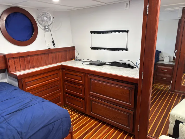 Restless T Yacht Photos Pics 1971 Sermons Expedition interior with wooden cabinetry, blue bedding, and wall-mounted fan.