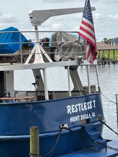 Restless T Yacht Photos Pics Blue boat "Restless T" docked, Huntsville, AL, with American flag, 1971 Sermons Expedition model.