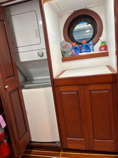 Restless T Yacht Photos Pics Laundry area on 1971 Sermons Expedition boat with washer, dryer, and cleaning supplies.