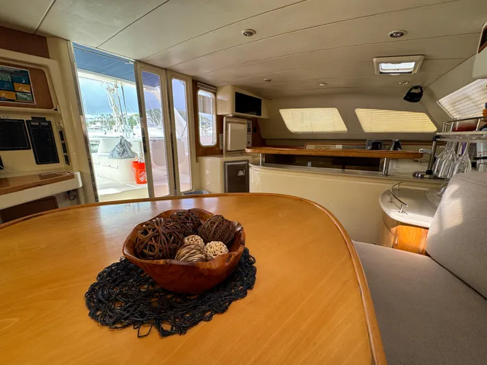 U Turn Yacht Photos Pics Interior of 2003 Leopard 47 yacht with wooden table and decorative bowl.