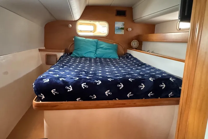 U Turn Yacht Photos Pics Cozy cabin interior of 2003 Leopard 47 yacht with nautical-themed bedding.