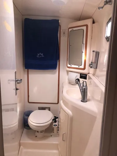 U Turn Yacht Photos Pics Compact bathroom in 2003 Leopard 47 yacht with sink, toilet, and mirror.