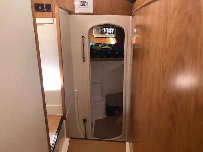 U Turn Yacht Photos Pics Interior of a 2003 Leopard 47 yacht with wooden paneling and a small doorway.