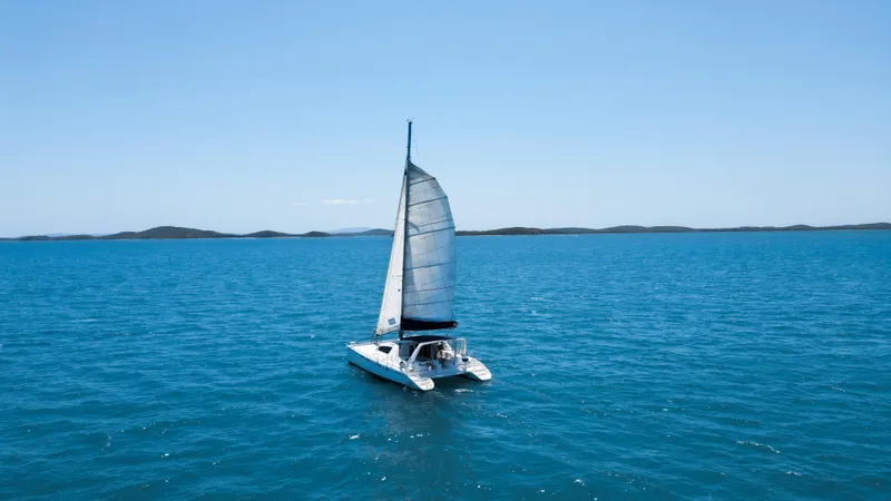 U Turn Yacht Photos Pics Sailing catamaran Leopard 47 on open sea, clear blue sky, 2003 model.
