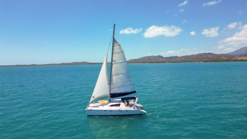 U Turn Yacht Photos Pics Sailing catamaran Leopard 47, 2003 model, cruising on clear blue ocean waters.