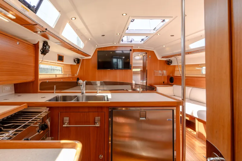 Age Gap Yacht Photos Pics Modern interior of 2023 Catalina 425 yacht with wood finish and stainless steel appliances.