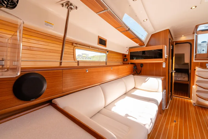Age Gap Yacht Photos Pics Luxurious interior of 2023 Catalina 425 yacht with wooden paneling and white seating.