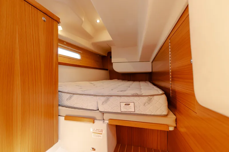 Age Gap Yacht Photos Pics Cozy cabin interior of 2023 Catalina 425 sailboat with wooden finish and comfortable bedding.