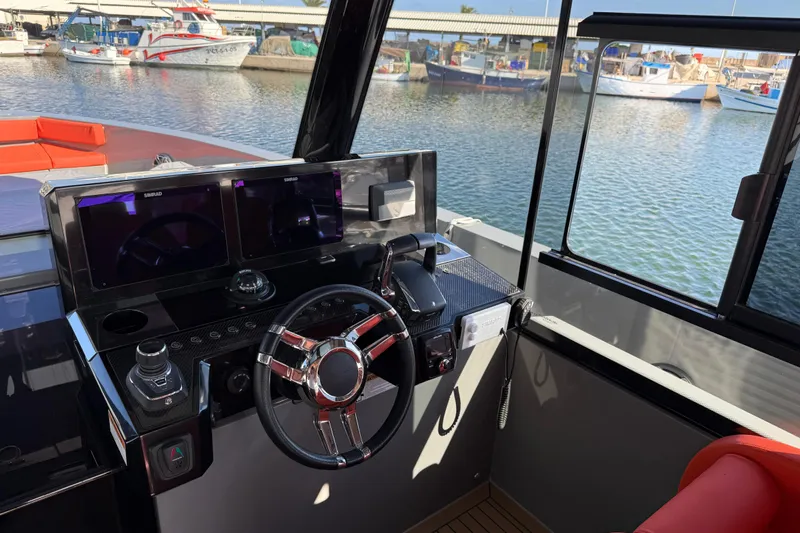  Yacht Photos Pics 2024 De Antonio Yachts D50 helm with modern controls and dual displays, docked at marina.