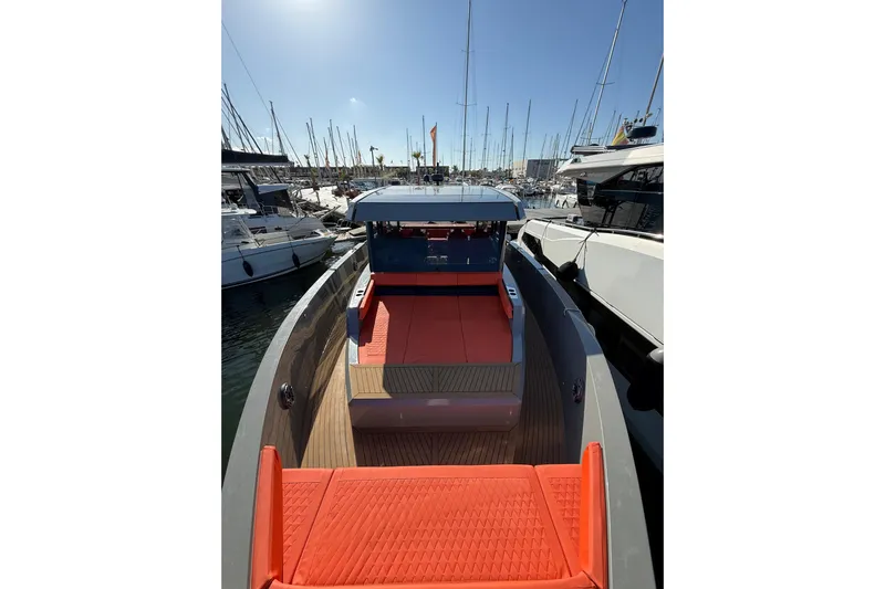  Yacht Photos Pics 2024 De Antonio Yachts D50 with vibrant orange seating, docked at a marina.