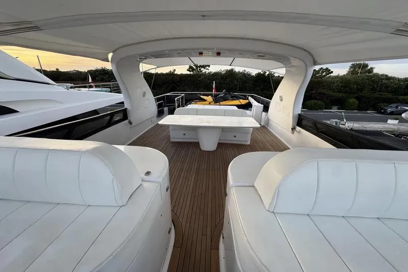 Yacht Photos Pics Luxurious 2009 Maiora 27 yacht deck with white seating and wooden flooring.