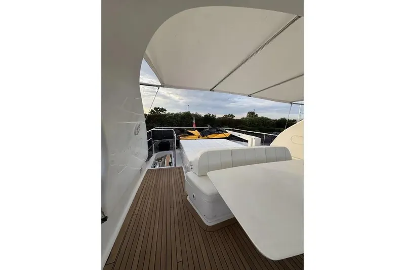  Yacht Photos Pics Luxurious 2009 Maiora 27 yacht deck with seating and canopy, featuring elegant wood flooring.