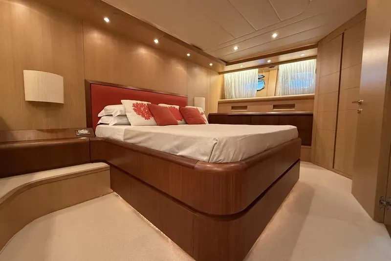  Yacht Photos Pics Luxurious bedroom interior of 2009 Maiora 27 yacht with elegant wood finishes and ambient lighting.