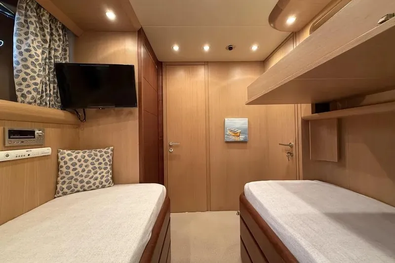  Yacht Photos Pics Interior of 2009 Maiora 27 yacht cabin with twin beds and wall-mounted TV.