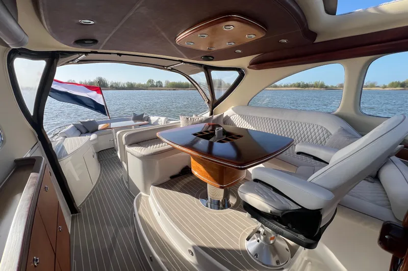 La Koko Yacht Photos Pics Luxurious 2012 Zeelander Z44 yacht interior with elegant seating and wooden table on a serene waterway.