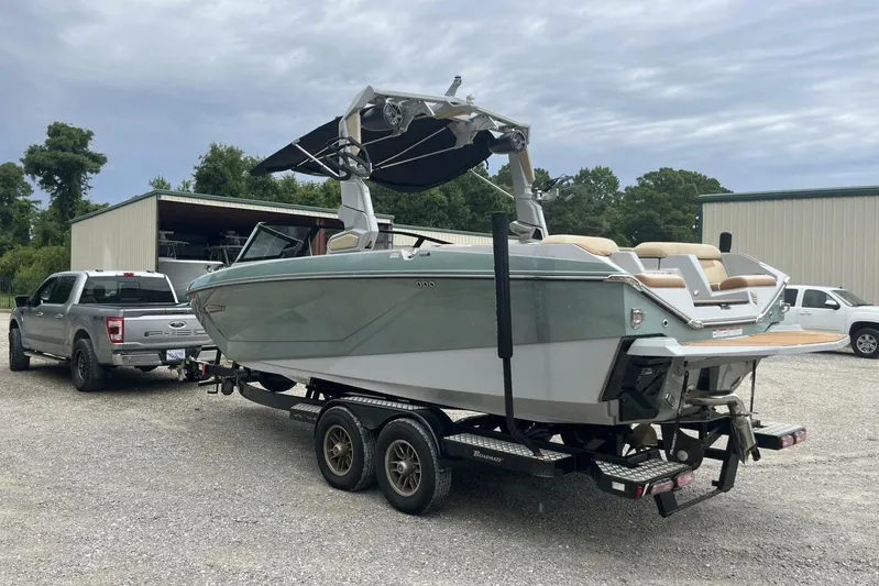  Yacht Photos Pics 2022 Nautique Super Air Nautique G23 boat on trailer, parked near a truck.