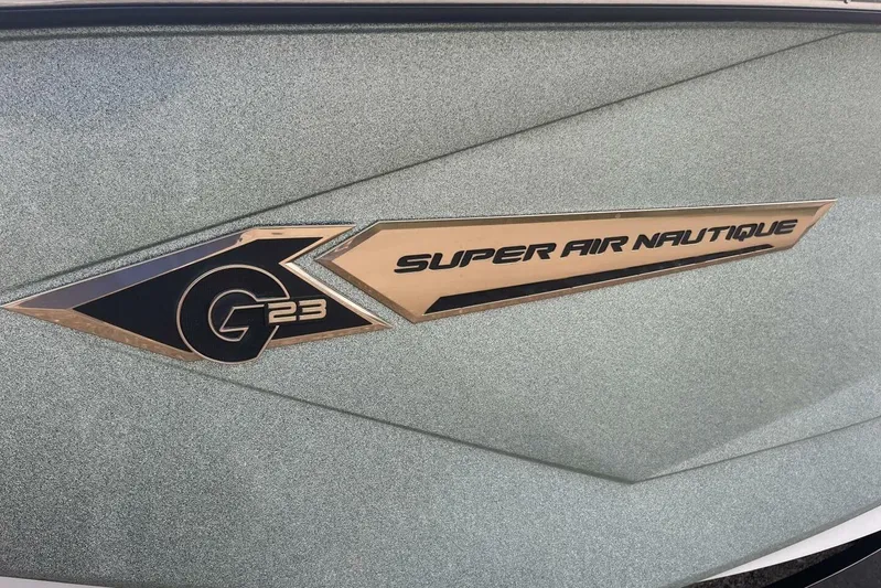  Yacht Photos Pics 2022 Nautique Super Air Nautique G23 logo on a textured surface.