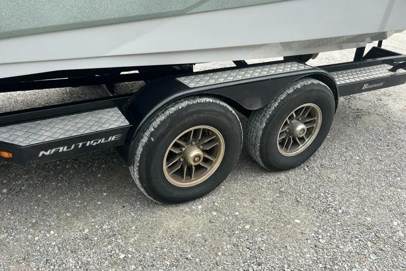  Yacht Photos Pics Trailer for 2022 Nautique Super Air Nautique G23 with dual wheels on gravel.