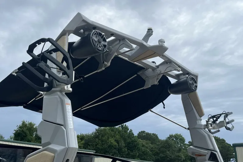  Yacht Photos Pics 2022 Nautique Super Air Nautique G23 wakeboard tower with speakers and racks under cloudy sky.