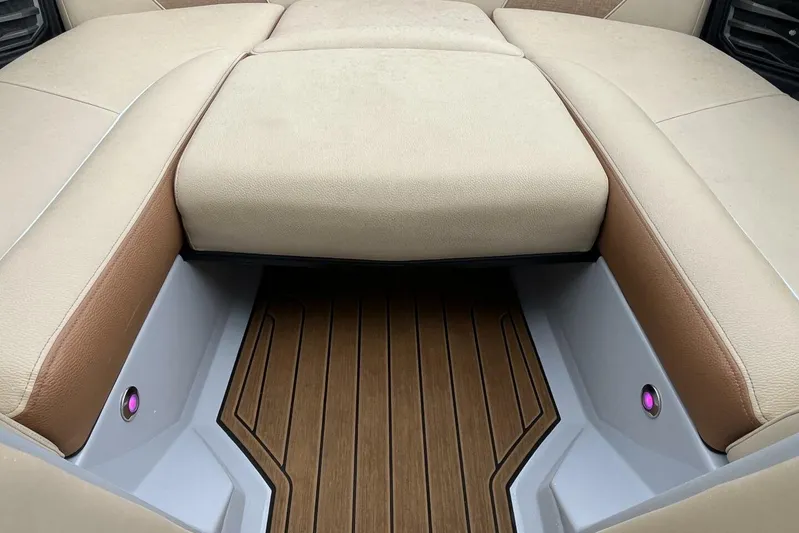  Yacht Photos Pics 2022 Nautique Super Air G23 interior with beige and brown seating, wood-style flooring.