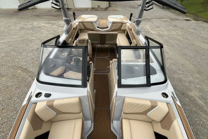 Yacht Photos Pics 2022 Nautique Super Air Nautique G23 boat interior with tan seating and open windshield.